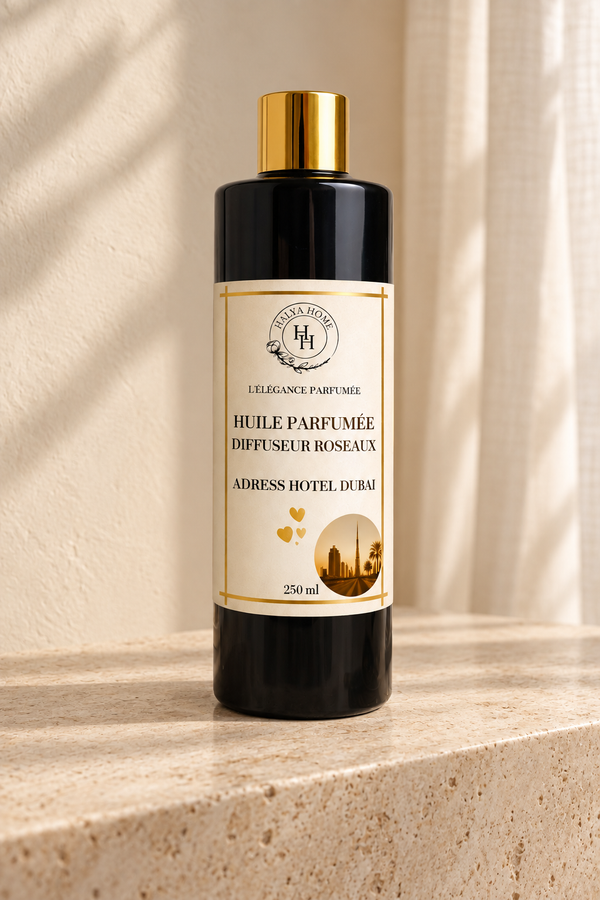 Huile parfumée Adress Hotel Dubaï Halya Home pour diffuseur à roseaux, flacon noir et doré de 250 ml sur du travertin.