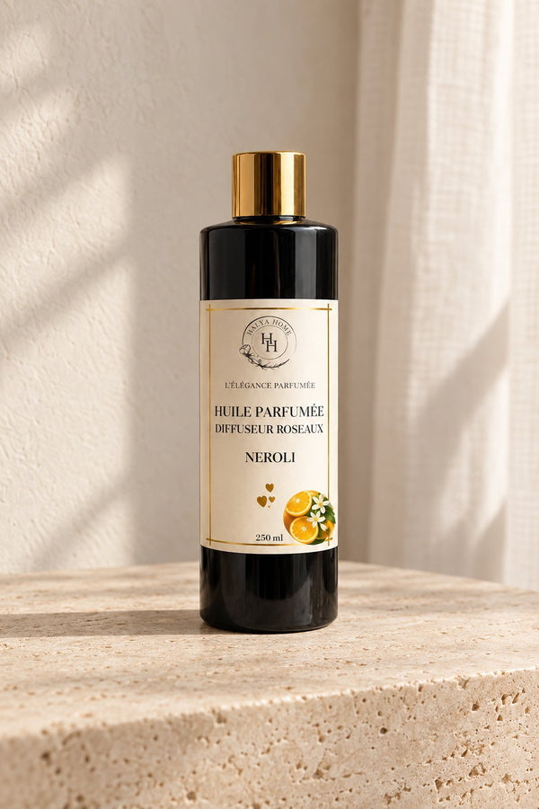 Huile parfumée Néroli Halya Home pour diffuseur à roseaux, flacon noir et doré de 250 ml sur du travertin.
