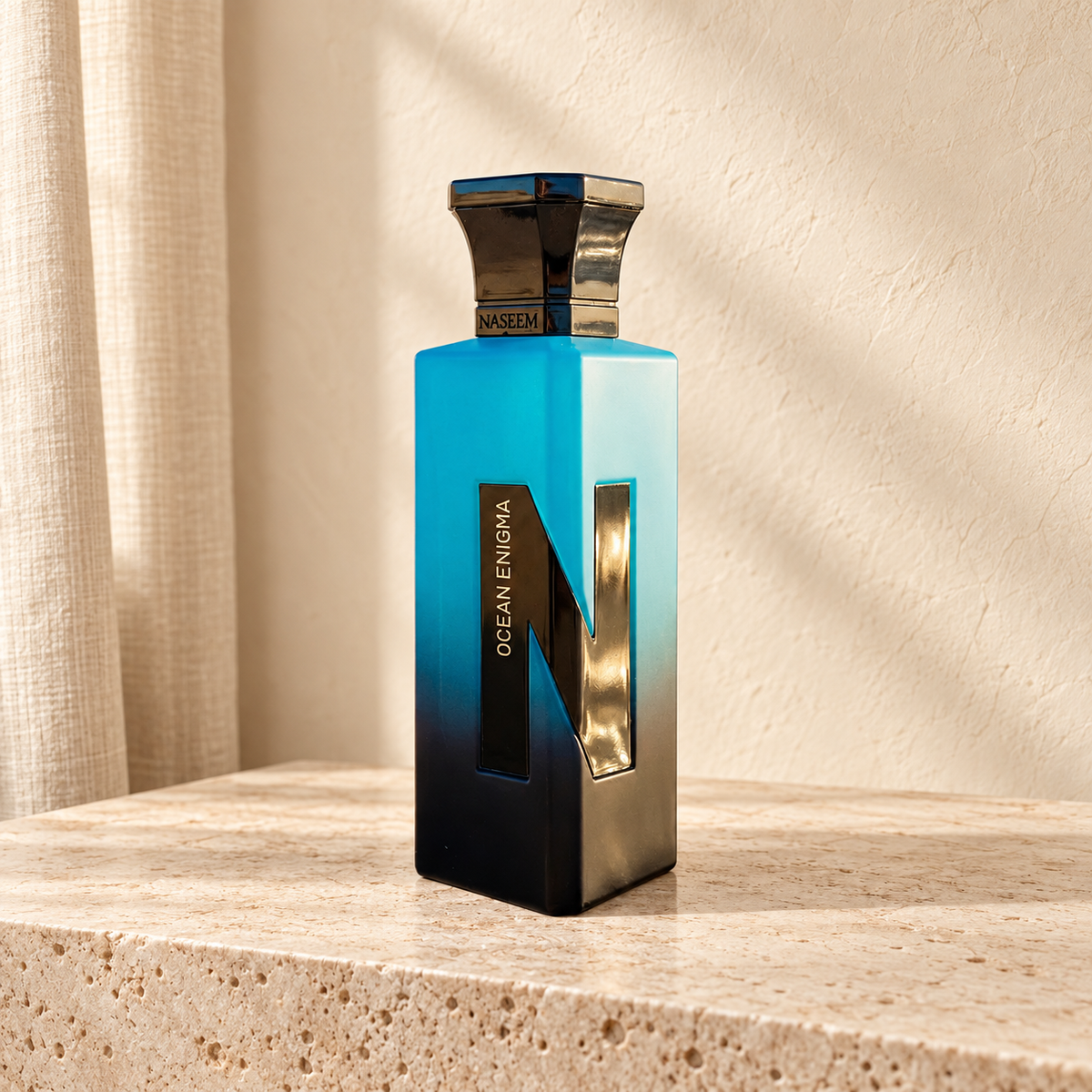 Ocean Enigma de Naseem 75 ml, flacon bleu et noir dans un décor ivoire et travertin — Halya Home.