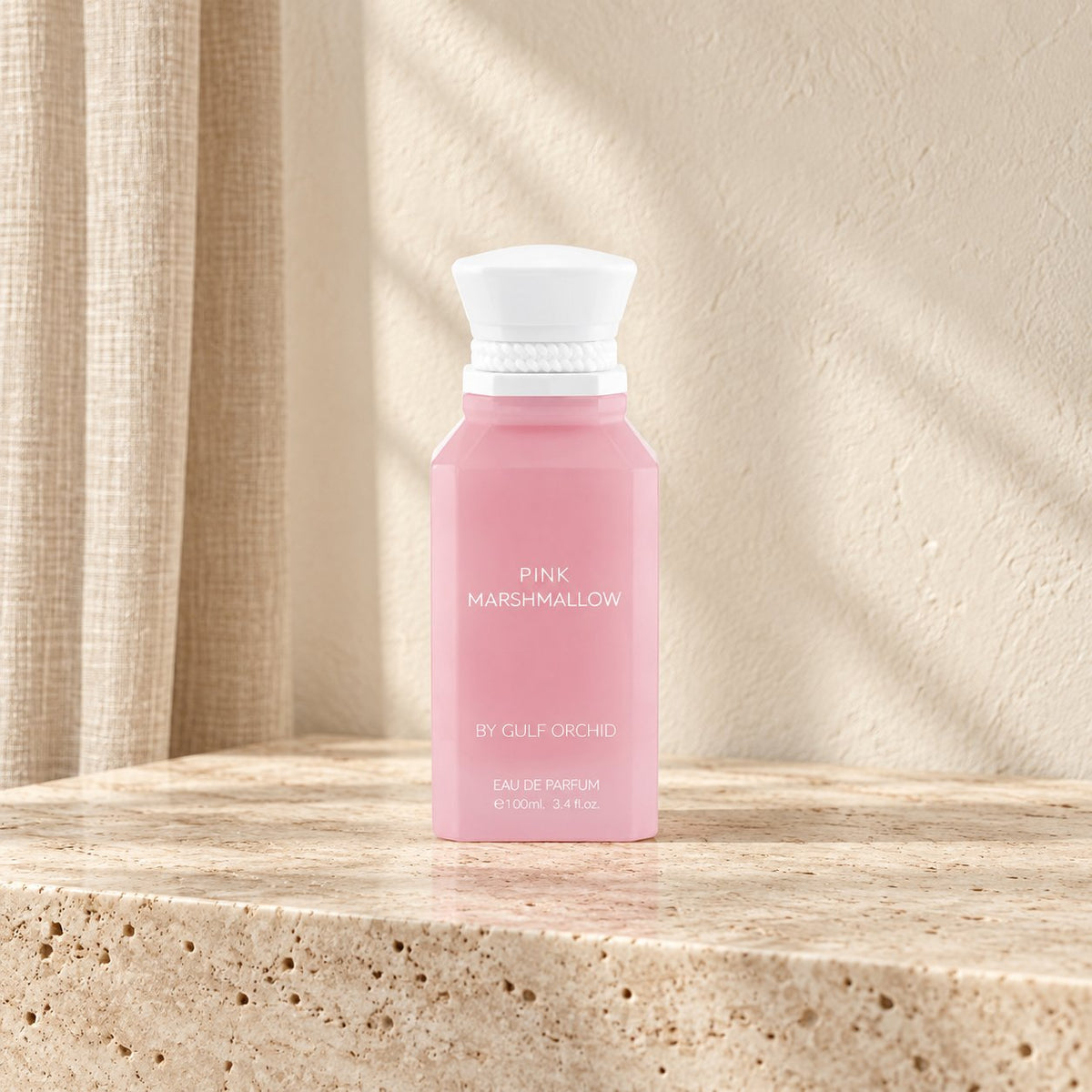 Pink Marshmallow de Gulf Orchid 100 ml, flacon rose et blanc sur une console en travertin — Halya Home.
