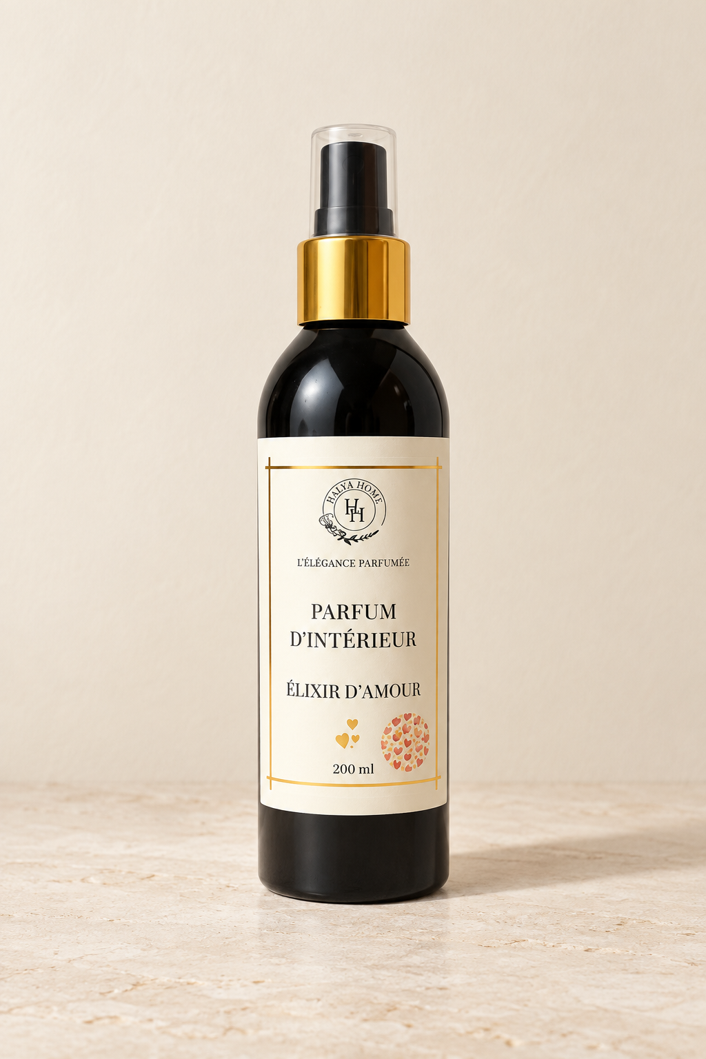 Spray d’intérieur Élixir d’Amour Halya Home 200 ml, flacon noir à bague dorée et capuchon transparent, sur fond ivoire.