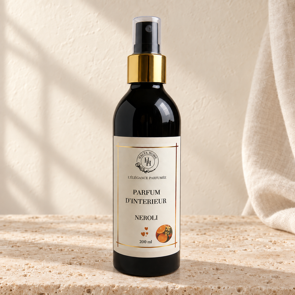 Spray d’intérieur Néroli Halya Home 200 ml, flacon noir à bague dorée et capuchon transparent dans un décor ivoire et travertin.